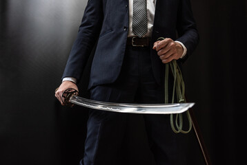 日本刀を構えるスーツ姿の人物