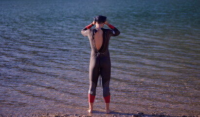 authentic triathlon athlete getting ready for swimming training
