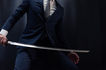 日本刀を構えるスーツ姿の人物