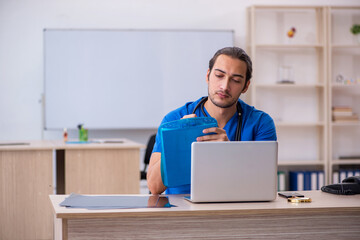Young male doctor taking notes in the clinic