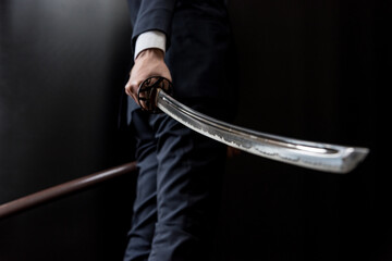 日本刀を構えるスーツ姿の人物