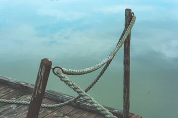 Lina barierka na drewnianym moście molo nad wodą