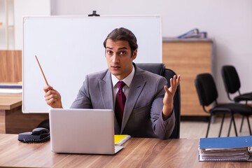 Young male business trainer in the office during pandemic