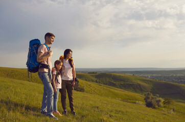 Family of backpackers in mountainous valley in summer nature