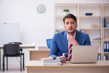 Young male employee suffering at workplace