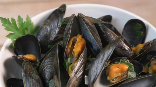 Moules mariniere, mussels, with cream, garlic and parsley in a iron bowl., Delicious French food, High quality video