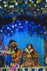 Beautiful idol of Lord Krishna and goddess Radha decorated with flowers, clothes and jewellery during Janmashtami celebration. 