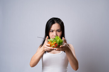 Asian woman eating salad for diet isolated over white background.