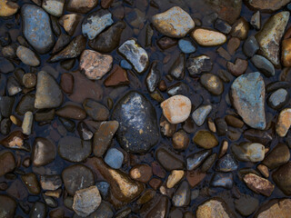 stones on the beach with textured water. Background for design. Soft light.