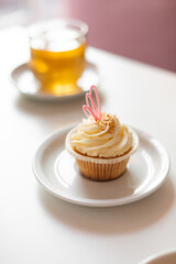 One delicious cupcake with pink decoration on white background
