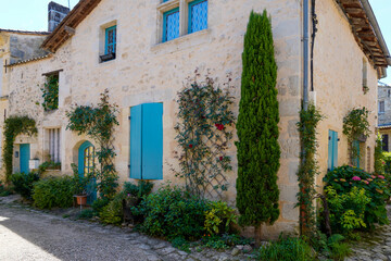 Fototapeta na wymiar medieval stones house blue shutter in Rions village Gironde France
