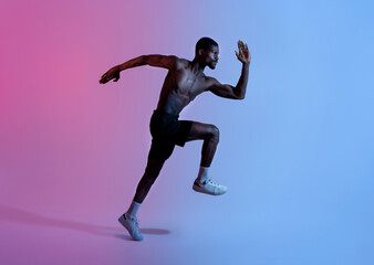 Fototapeta na wymiar Full length of strong black athlete in sportswear running in neon light, side view. Active lifestyle concept