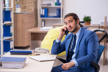 Young male employee looking after new born at workplace