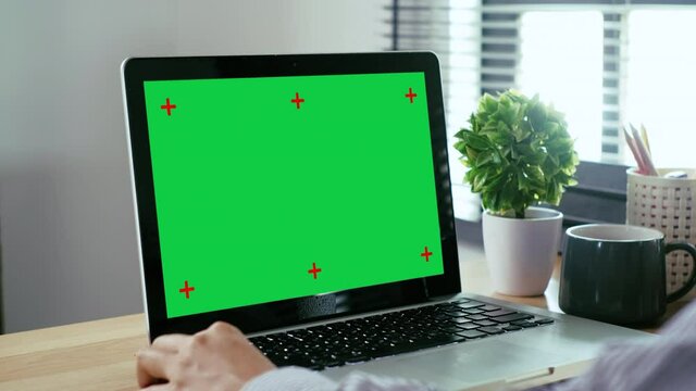 Back view of Business woman looking at chroma key green screen display in home office, Work from home concept.