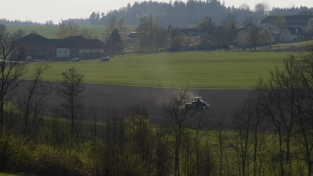 tractor harrowing on field in spring