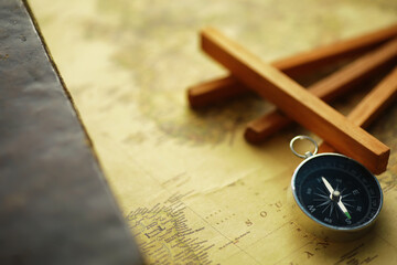 Travel and adventure search concept. Vintage aged map with a shabby book and compass. Shabby book and compass on the table.