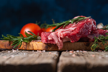 Fresh piece of beef, steak with vegetables. On a blue background.