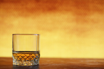 A glass of hard alcohol with ice on a bar counter. Whiskey with soda in a glass. Advertising alcoholic drink.