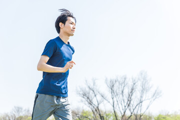 公園でランニングをする若い男性