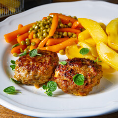 Homemade meatballs with french fries and vegetables