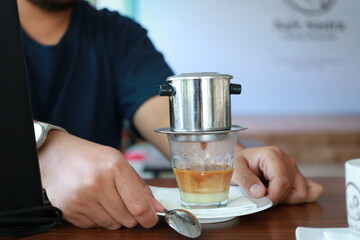 Fototapeta na wymiar Vietnam Drip Coffee. Traditional Method of vietnamese coffee. dripping coffee on condense milk
