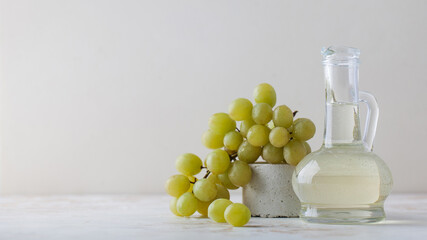 Organic vegetable oil from grape seeds in a glass bottle with green grapes. 