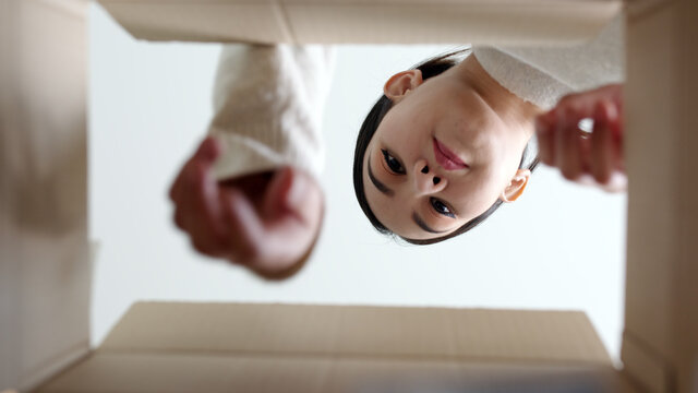 Bottom up inside box view asia woman open medicine carton receive postal parcel mail, look inside aid box at home. Girl unbox pharmacy package delivery service telehealth telemedicine online concept.