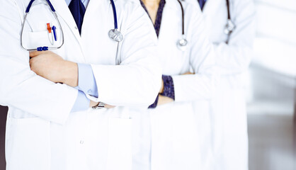 Group of modern doctors standing as a team with crossed arms and stethoscopes in hospital office. Physicians ready to examine and help patients. Medical help, insurance in health care, best desease