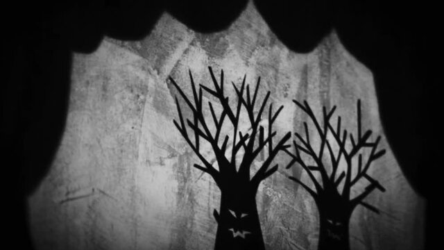 Vintage animation, shadow theatre on a wall. Pantomime, fantasy story. Halloween scene, black and white storytelling. Classic fable for children, creepy puppets.