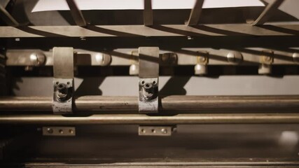 Old, metal letters, printing machines. Vintage, antique metal machinery working in slow motion, classic, traditional workshop. Man creating a book.