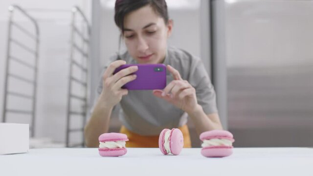 Young girl takes pictures of bright macaroons