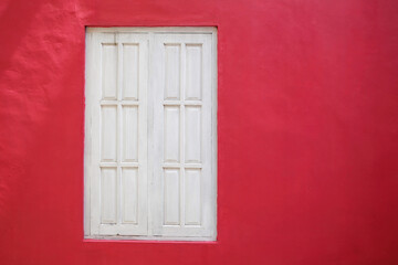 Old white wood window on red wall