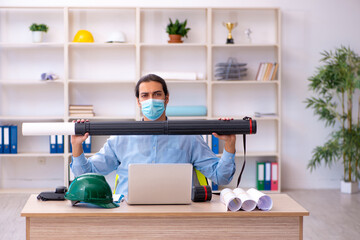 Young male architect working in the office during pandemic