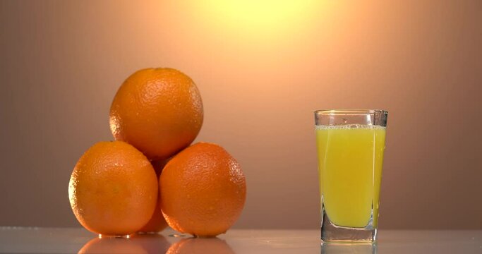 man's hand takes the glass of fresh orange juce from the table. sunset mood