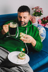 Un hombre soltero desayunando rosquillas y cerveza negra para celebrar el Día de San Patricio
