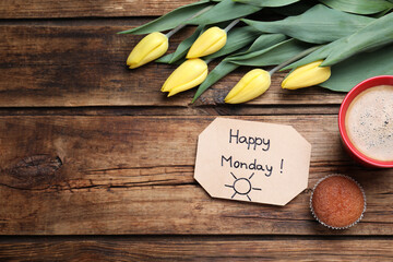 Happy Monday message, aromatic coffee, cupcake and tulips on wooden table, flat lay. Space for text