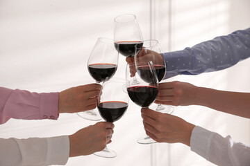 People clinking glasses of wine on white background, closeup