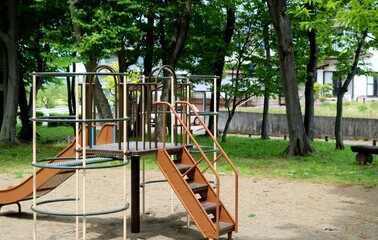 Fototapeta premium 新緑の中子供たちを待つ滑り台 遊具 風景