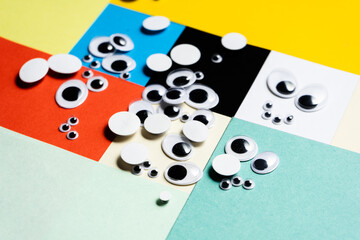 A bunch of toy eyes scattered against a multi-colored background