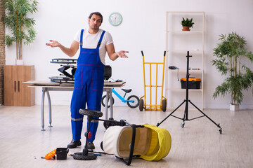 Young male repairer repairing perambulator indoors