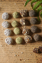 Homemade vegan peanut energy chocolate candy truffles with matcha, chia seeds, almonds and coconut flakes topping
