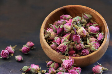 Small bud roses in bowl on wooden table