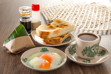 Oriental breakfast set in Malaysia consisting of coffee, nasi lemak, toast bread and half-boiled egg