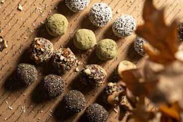 Homemade vegan peanut energy chocolate candy truffles with matcha, chia seeds, almonds and coconut flakes topping