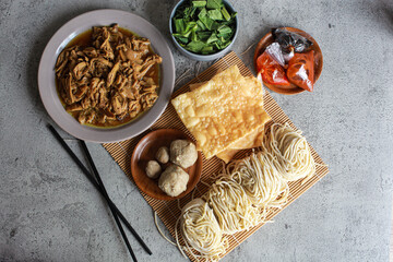 Top view of Indonesian chicken noodles ingredient called mie ayam and served with meatballs