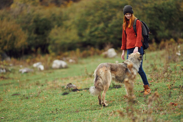 woman tourist with dog walking in nature travel pass freedom of adventure