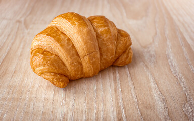 Close up of fresh delicious croissants on wooden background