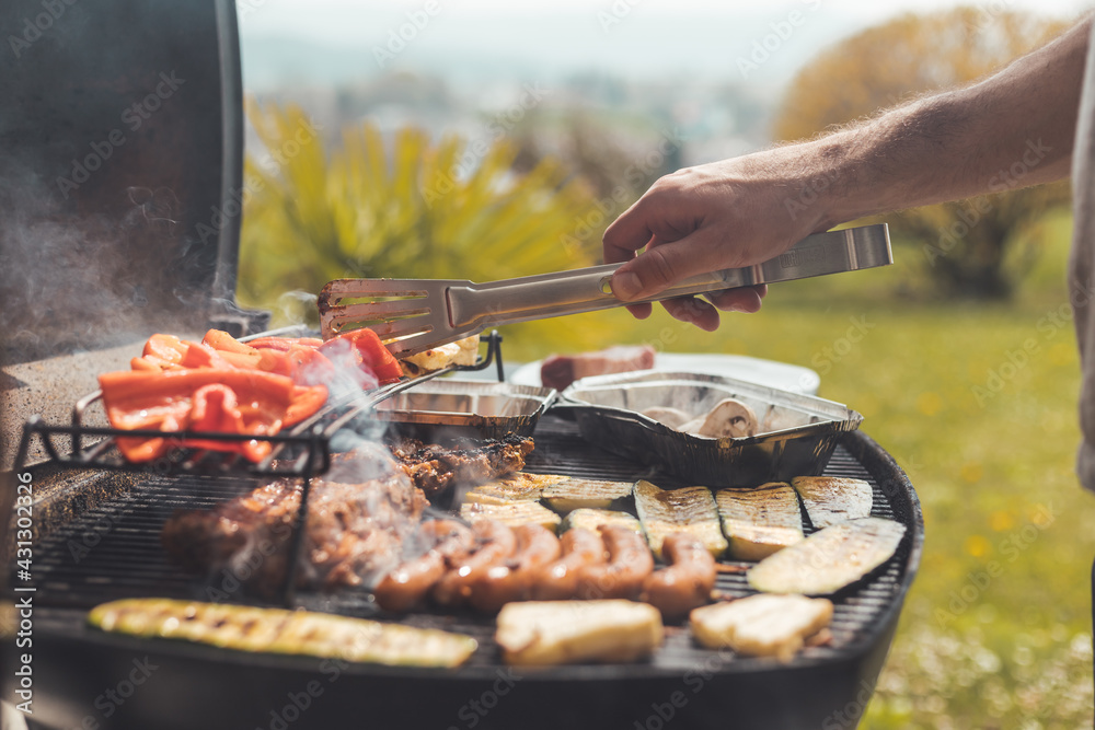 Wall mural bbq on weekend. sausages, steak, cheese and vegetables on gas grill. outdoors.