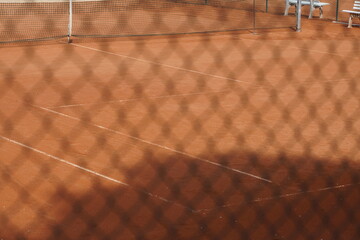 Sauberes Tennis Spiel Feld mit rotem Sand, weißen Markierungen des Felds und einem Zaun aus...