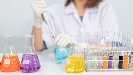 A young woman researcher, doctor, scientist, or laboratory assistant working with plastic medical tubes to research, examine scientific experiments in a modern laboratory. Education stock photo